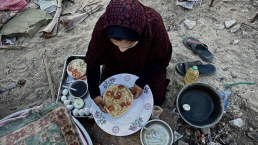 Palestinietė ruošia maistą tarp griuvėsių Chan Junise (Gaza)