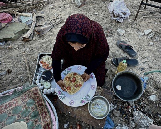 Palestinietė ruošia maistą tarp griuvėsių Chan Junise (Gaza)